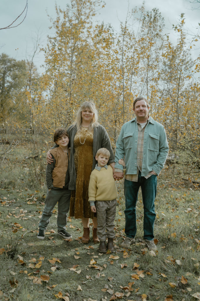 family standing near yellow leaved trees, 2 sons with mom and dad