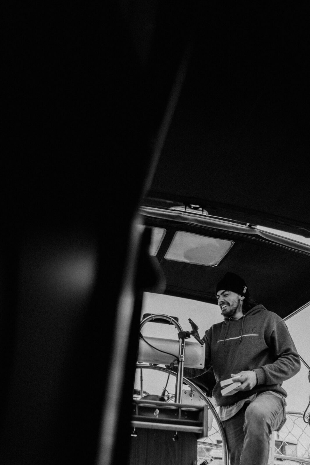 black and white, sailboat captains wheel with sailor